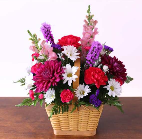 basket of mixed fresh flowers with pink, red, white, and purple blooms by Studley Flower Gardens