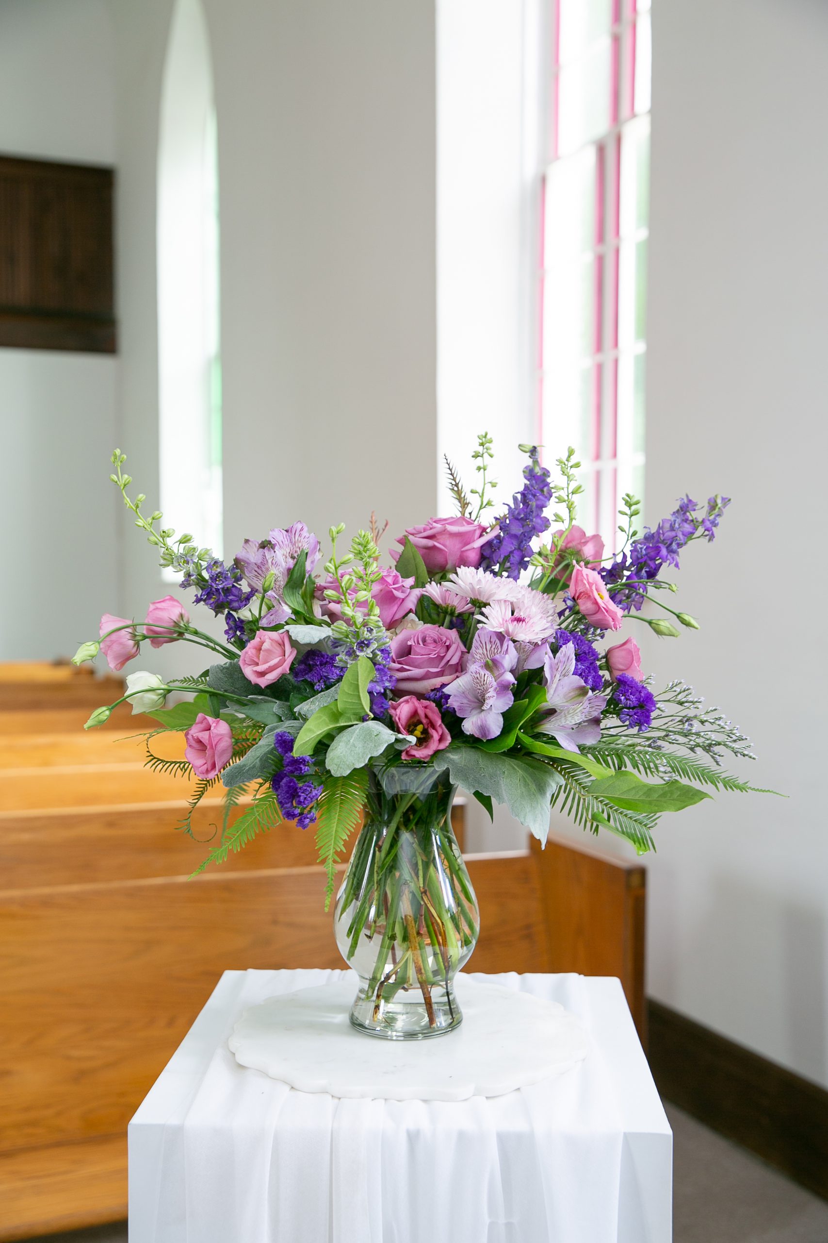 Amethyst tribute bouquet with lavender roses and chrysanthemums in glass vase by Studley Flower Gardens