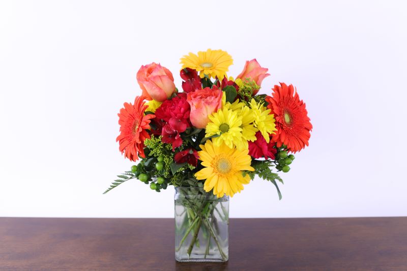 Citrus Splash Bouquet by Studley’s with vibrant orange and yellow blooms by Studley Flower Gardens