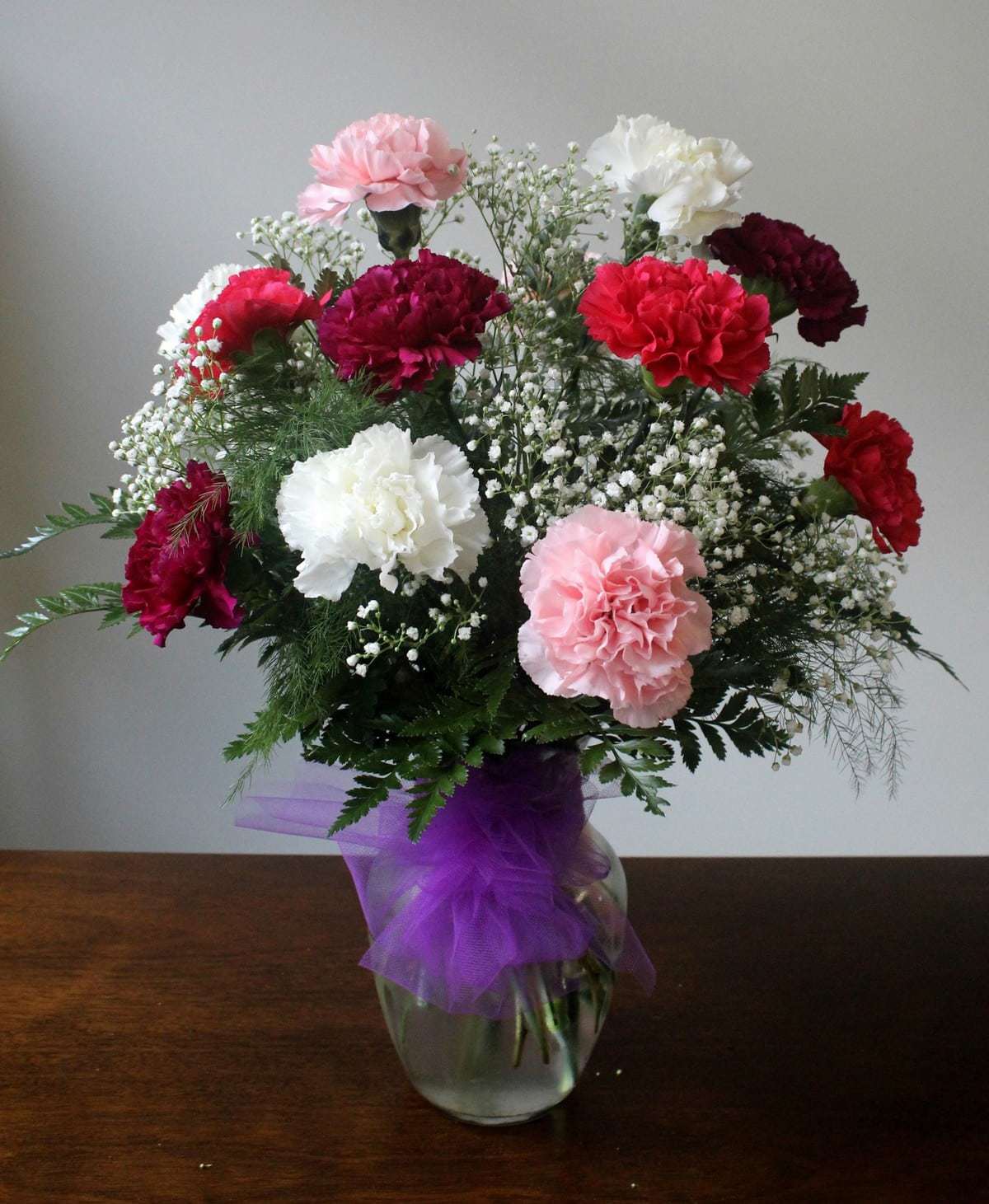 Classic carnation bouquet in a clear vase by Studley Flower Gardens