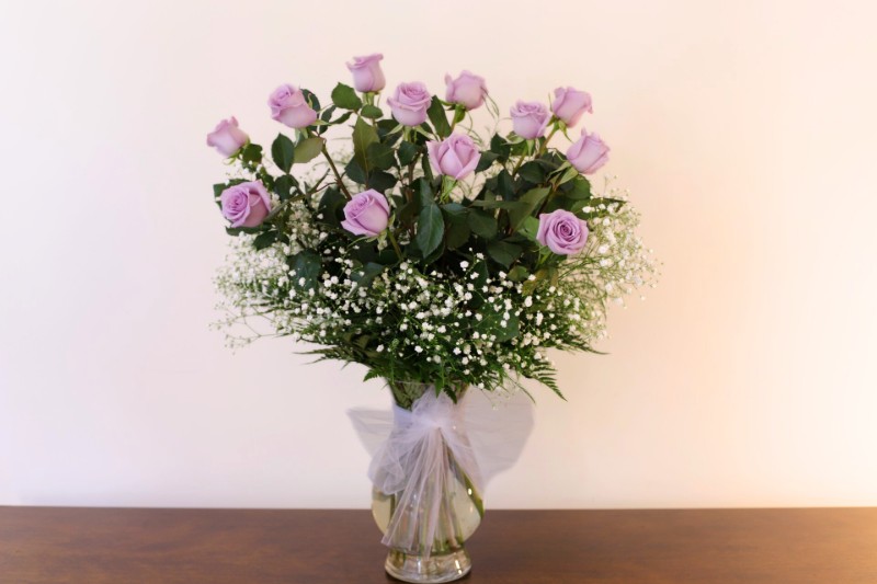 One dozen lavender roses with white Baby's Breath by Studley Flower Gardens